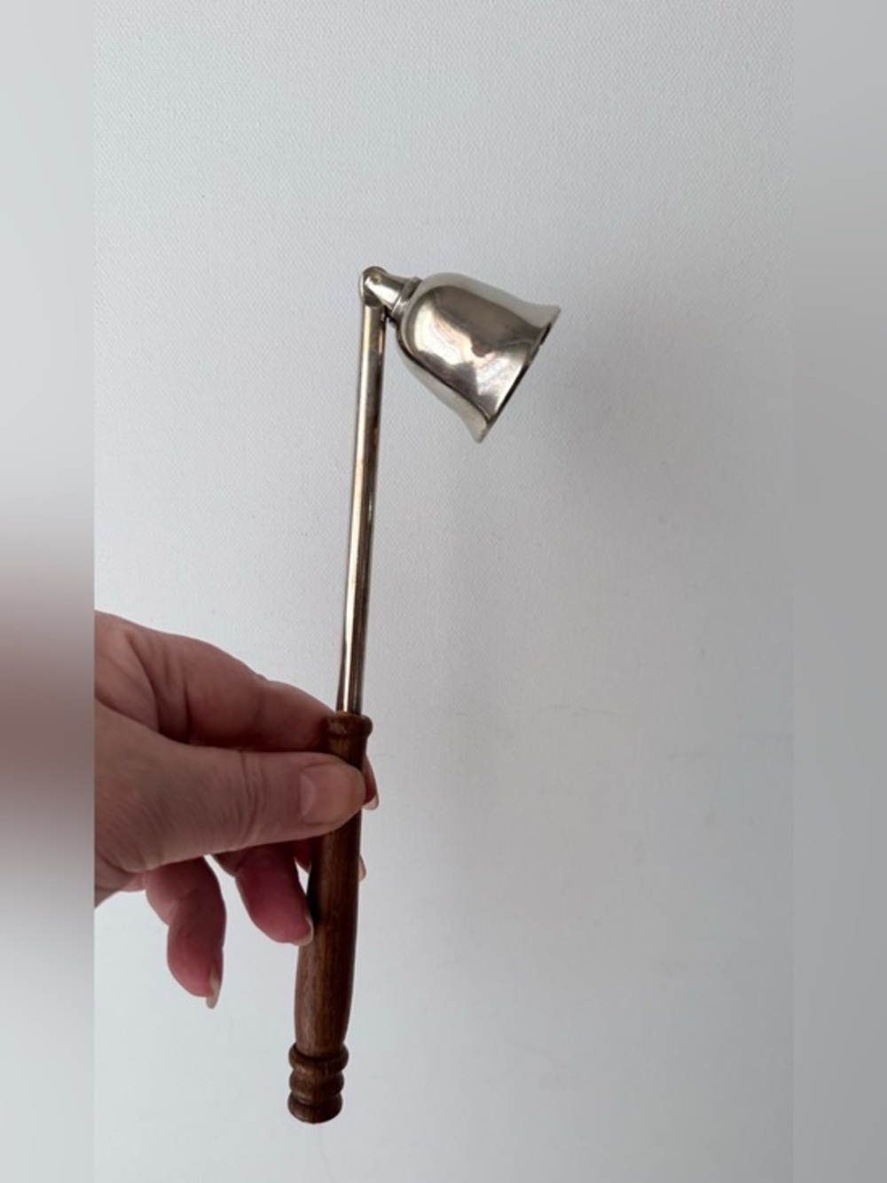 vintage candle snuffer constructed with a silver-plated bell wooden handle.